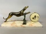 statue of a dog jumping over a clock on a marble base