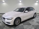 BMW Série 3 berline, blanche, avec des jantes noires et des roues chromées