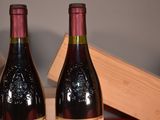 two bottles of wine sitting on a table next to each other