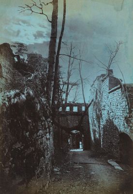 une vieille photo d'une ruelle avec un bâtiment en pierre