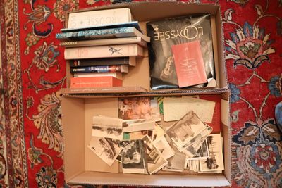 une boîte remplie de livres posée sur un tapis