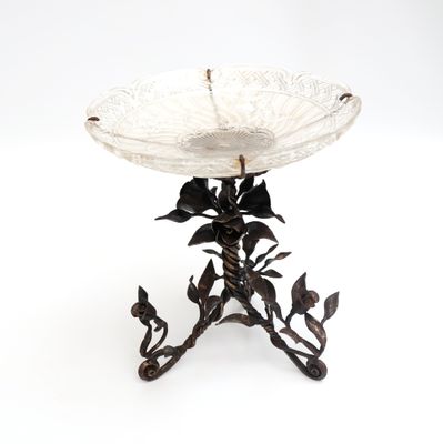 un bol en verre posé sur un socle en métal et orné de fleurs