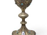 an image of a silver cup with blue stones on it