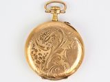 a close up of a gold pocket watch on a white surface