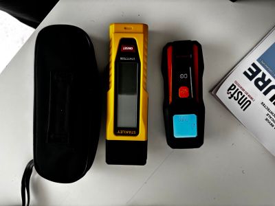 trois appareils électroniques posés sur une table à côté d'un livre