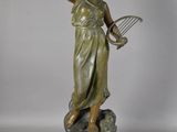 statue en bronze représentant une femme tenant une raquette de tennis et une balle de tennis