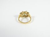 a close up of a gold ring with a green stone