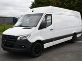 La camionnette blanche est garée sur le parking près des arbres.