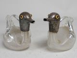 two glass ducks that are sitting next to each other