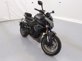une moto noire garée dans une pièce aux murs blancs