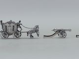 une figurine en argent représentant une calèche et une voiture