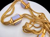 a necklace with a gold chain and a lighter on it