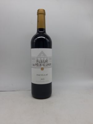 la bouteille de vin rouge est posée sur une surface blanche
