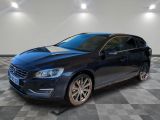 une Volvo break bleue garée dans une pièce au sol carrelé