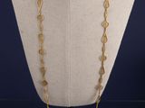 un collier en or sur un mannequin, sur fond bleu