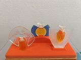 three perfume bottles sitting on top of an orange box