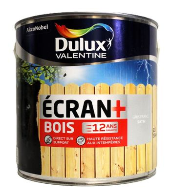 un pot de peinture avec une clôture en bois en arrière-plan