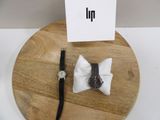une planchette en bois sur laquelle sont posés une montre et un nœud papillon