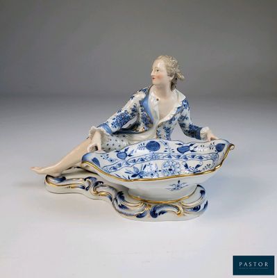 une figurine représentant une femme assise sur une assiette