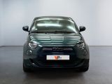 the front view of a small green car in a white room