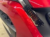 a close up of a red car with a ruler attached to it