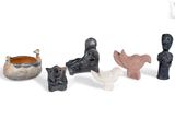 five figurines of different shapes and sizes on a white surface