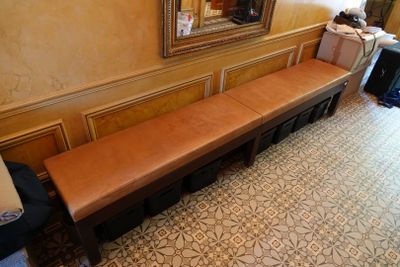 a long bench in the corner of a room