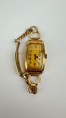 l'image d'une montre-bracelet en or entourée d'une chaîne