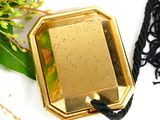 a picture of a gold plate with a black cord around it