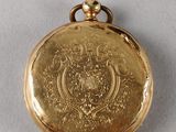 an image of a gold pocket watch sitting on top of a white surface