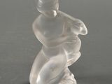 une figurine en verre représentant un homme sur une planche de surf