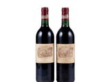 two bottles of red wine sitting next to each other on a white surface