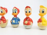three little plastic ducks are lined up in a row