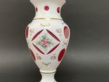 a white vase with a red and pink design on it