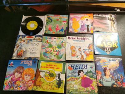de nombreux livres pour enfants posés sur une table, à côté d'un disque