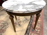 une table au plateau en marbre posée sur un tapis au sol