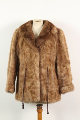 brown fur coat on a mannequin stand against a white wall