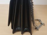 a small black purse with a chain hanging from it