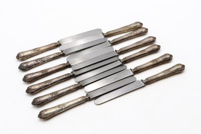 six couteaux sont empilés les uns sur les autres sur une surface blanche
