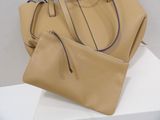 beige leather handbag with matching purse on display on white surface