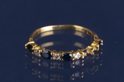 gros plan d'une bague en or avec des pierres noires et blanches