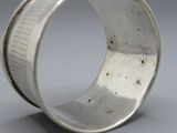 une photo en gros plan d'une bague en argent posée sur une table