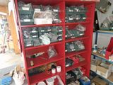 a red bookcase filled with assorted items in a garage