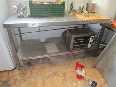 a metal table with a basket on top of it in a kitchen