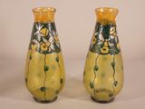 two yellow vases with green and white designs on them