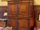 une salle à manger avec une table et des chaises, et un buste d'homme accroché au mur