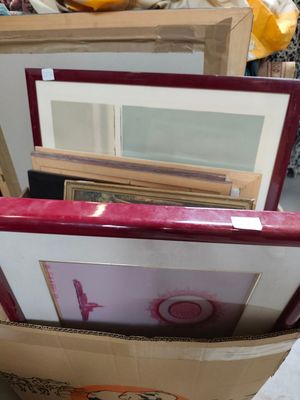 a box full of framed pictures on the floor