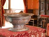 a large metal bowl sitting on a table in the middle of a room