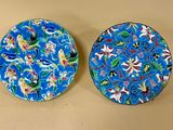 deux assiettes bleues ornées de motifs floraux, posées sur une table