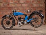 a blue motorcycle that is parked in front of a brick wall